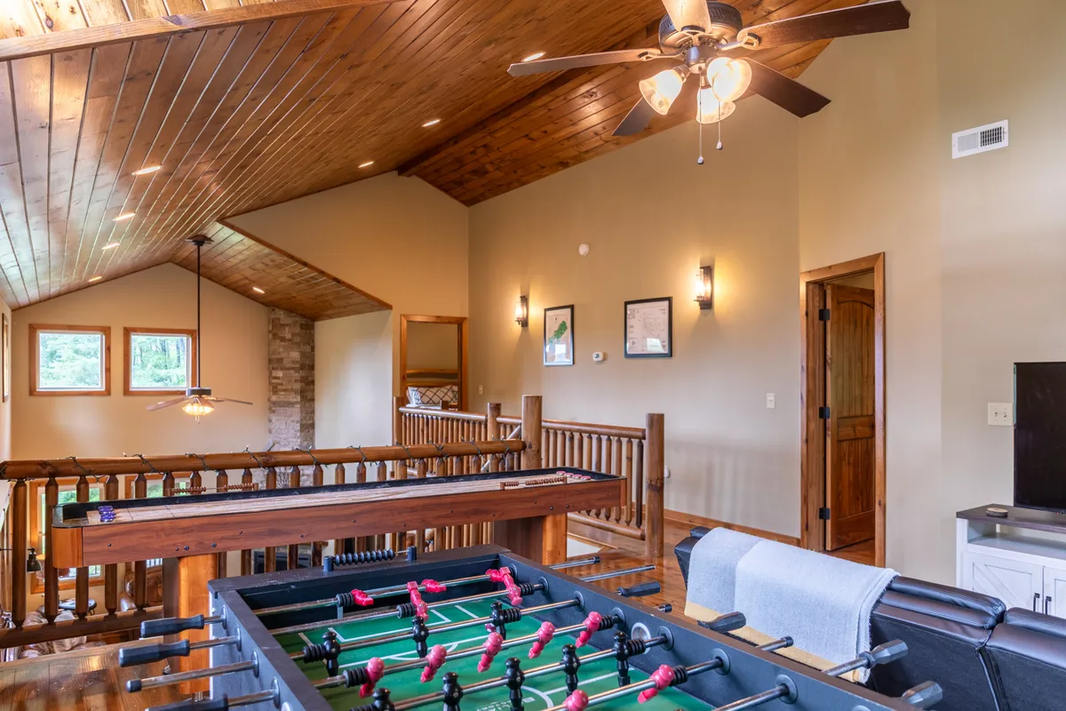 Inside the cabin, this game loft features a foosball table, large windows that let in natural light, and a relaxed recreational area. The space is warm and welcoming, perfect for friendly competitions and socializing after outdoor adventures.